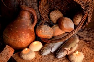 two-fish-and-five-loaves-of-bread-with-candle-light-and-an-antique-jar